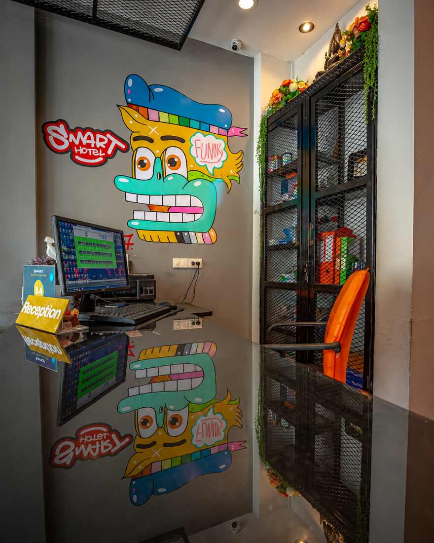 เคาน์เตอร์ต้อนรับของ Smart Hotel พร้อมพื้นที่เจ้าหน้าที่และผนังภาพวาดด้านหลัง